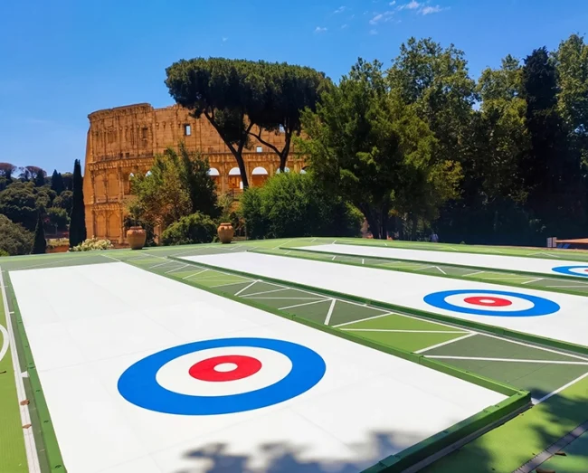 Piste di curling sintetico eco-efficienti Xtraice nel Parco del Colle Oppio con il Colosseo sullo sfondo a Roma.
